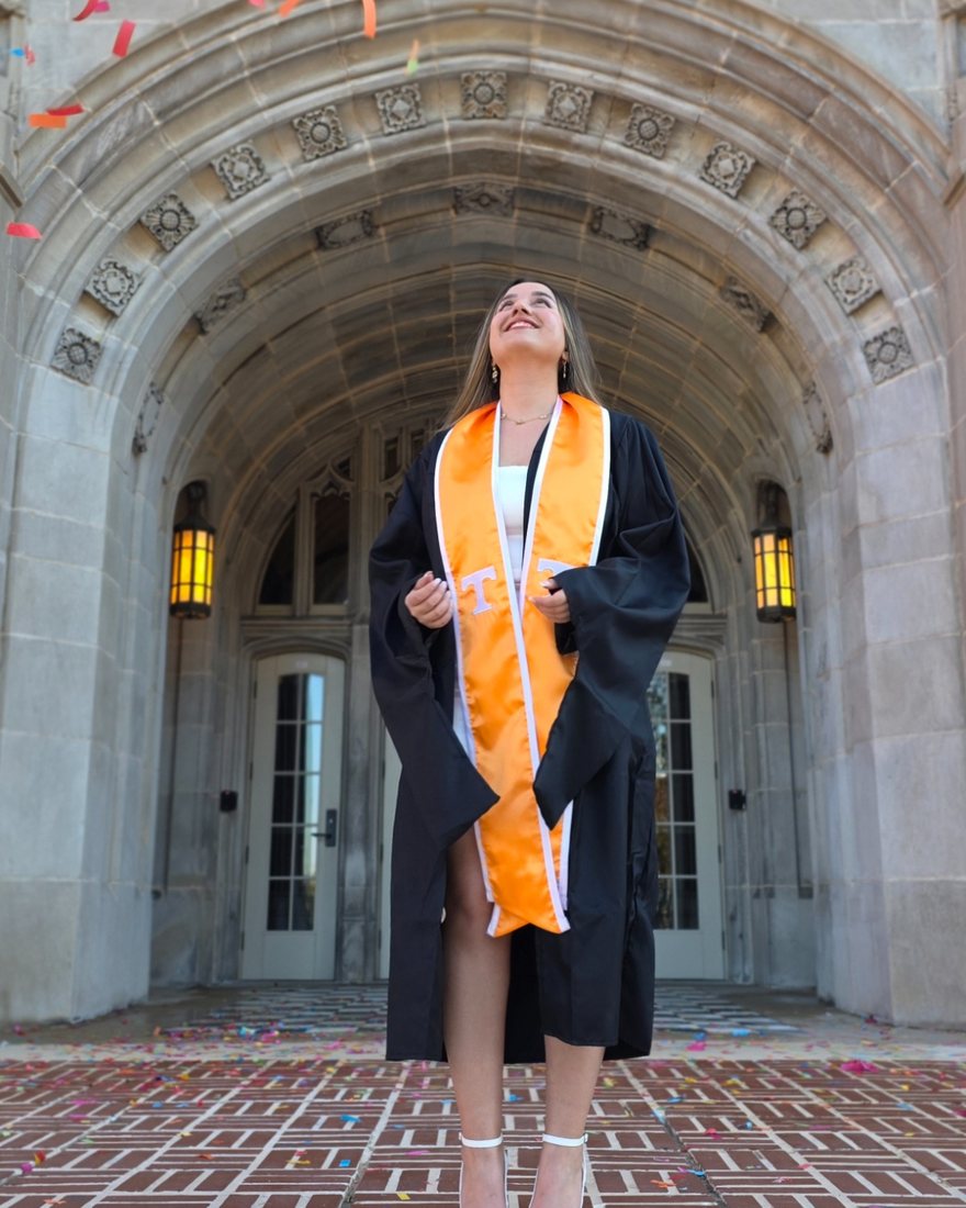 Nooshin Rajabi at her University of Tennessee graduation, standing before the Ayres Hall arch in an orange stole
